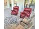 Comfortable seating area with classic red chairs, wicker chairs and light blue rug at 1415 Beach Club, Apollo Beach, FL 33572