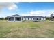 Expansive backyard features a large lawn, trampoline, and covered patio, perfect for outdoor enjoyment and entertaining at 14902 Sweat Loop Rd, Wimauma, FL 33598