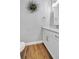 Bathroom with white cabinets, hardwood floors, granite countertop and decorative holiday wreath at 14902 Sweat Loop Rd, Wimauma, FL 33598