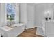 Bright bathroom featuring a modern tub, large window, and stylish vanity with double sinks at 14902 Sweat Loop Rd, Wimauma, FL 33598