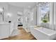 Bright bathroom featuring a soaking tub, glass shower, and modern finishes next to a window at 14902 Sweat Loop Rd, Wimauma, FL 33598