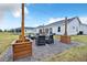 Charming firepit area with Adirondack chairs is surrounded by a pea gravel patio, wooden planters, and string lights at 14902 Sweat Loop Rd, Wimauma, FL 33598