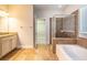 Bathroom featuring a tub, tiled shower, and granite countertops with an open view to a walk-in closet at 16226 Bayberry View Dr, Lithia, FL 33547