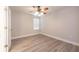Inviting bedroom with wood-look floors, ceiling fan, and ample natural light from the window at 16226 Bayberry View Dr, Lithia, FL 33547