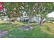 Landscaped front yard features lush lawn, mature trees, and charming exterior of a well-maintained home at 2115 N Halcyon Dr # 510, Sun City Center, FL 33573