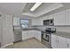 Bright kitchen featuring stainless steel appliances, white cabinets, and granite countertops at 2115 N Halcyon Dr # 510, Sun City Center, FL 33573
