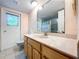 Bathroom featuring a vanity, toilet, and a window with a garden view, accentuated by an octagon mirror at 232 Pinecrest Dr, Palm Harbor, FL 34683