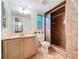 Bathroom featuring a vanity, toilet, window, and glass-enclosed shower with neutral-toned tile at 232 Pinecrest Dr, Palm Harbor, FL 34683