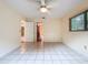 Well-lit bedroom with tile flooring, neutral walls, a ceiling fan, and natural light from the window at 232 Pinecrest Dr, Palm Harbor, FL 34683
