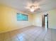 The bedroom has neutral paint, tile floors, a ceiling fan, and a window with coverings at 232 Pinecrest Dr, Palm Harbor, FL 34683