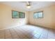 Bright bedroom with tile floors, ceiling fan and natural light provided by two windows at 232 Pinecrest Dr, Palm Harbor, FL 34683