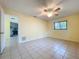 Sunny bedroom with tile flooring and neutral walls, offering a view of the fireplace and natural light at 232 Pinecrest Dr, Palm Harbor, FL 34683
