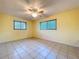 Well-lit bedroom with tile flooring, neutral walls, and natural light from windows with a ceiling fan at 232 Pinecrest Dr, Palm Harbor, FL 34683