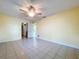 Neutral bedroom with tile flooring and a ceiling fan, offering multiple entry points and a sunlit ambiance at 232 Pinecrest Dr, Palm Harbor, FL 34683