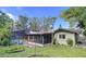 Rear exterior view of home featuring a screened-in patio, pool and well-maintained lawn at 232 Pinecrest Dr, Palm Harbor, FL 34683