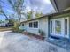 Welcoming front entrance with a decorative glass door, beautiful landscaping, and a stone walkway at 232 Pinecrest Dr, Palm Harbor, FL 34683