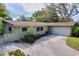 Charming single-story home featuring an attached garage, lovely landscaping, and inviting curb appeal at 232 Pinecrest Dr, Palm Harbor, FL 34683