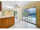 Bright kitchen featuring tile flooring, a ceiling fan, wood cabinetry, and an open concept design at 232 Pinecrest Dr, Palm Harbor, FL 34683