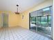 Bright living room features tile floors and access to a screened in patio for indoor-outdoor living at 232 Pinecrest Dr, Palm Harbor, FL 34683