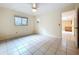 Neutral living room with tiled floors, a window, and view into the adjacent kitchen area at 232 Pinecrest Dr, Palm Harbor, FL 34683