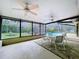 Covered patio features a dining table, ceiling fans, and views of the screened-in pool at 232 Pinecrest Dr, Palm Harbor, FL 34683