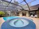 Beautiful pool and attached spa with blue mosaic tile inside a screened-in enclosure at 232 Pinecrest Dr, Palm Harbor, FL 34683