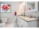 Bathroom with granite vanity with double sinks, modern faucets and handles, and large decorative wall art at 260 Sw Lincoln N Cir, St Petersburg, FL 33703