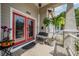 Covered porch with tile floor, red glass door, bench, and attractive plants at 260 Sw Lincoln N Cir, St Petersburg, FL 33703