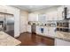 Well-lit kitchen featuring granite countertops, white cabinetry, and modern appliances at 260 Sw Lincoln N Cir, St Petersburg, FL 33703