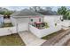 Rear view of the home featuring a white fence, patio area, and two-car garage at 260 Sw Lincoln N Cir, St Petersburg, FL 33703