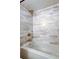 A close up on the recently remodeled tub and shower with white subway tile and gold hardware at 2614 Cove Cay Dr # 409, Clearwater, FL 33760