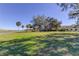 Expansive lawn leading up to a building, lush greenery, and a glimpse of the water enhance the property's appeal at 2614 Cove Cay Dr # 409, Clearwater, FL 33760