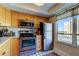 Kitchen featuring stainless steel appliances, light wood cabinetry, and natural light from the large window at 2614 Cove Cay Dr # 409, Clearwater, FL 33760