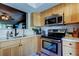 Kitchen featuring stainless steel appliances, a stylish faucet and an open layout to the living area at 2614 Cove Cay Dr # 409, Clearwater, FL 33760