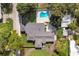 Aerial view of a modern home with a backyard pool surrounded by mature trees and greenery at 2679 Haines Bayshore Rd, Clearwater, FL 33760