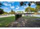 Large backyard with green lawn, mature trees, privacy fence, and ample space for outdoor activities and relaxation at 2679 Haines Bayshore Rd, Clearwater, FL 33760