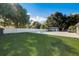 Spacious backyard featuring a well-manicured lawn, mature trees, a pool, and a fence for added privacy at 2679 Haines Bayshore Rd, Clearwater, FL 33760
