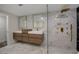 Modern bathroom with double vanities, a glass-enclosed shower with gold fixtures, and marble-style walls at 2679 Haines Bayshore Rd, Clearwater, FL 33760