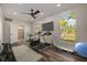 Inviting bedroom featuring windows with natural light, ceiling fan, and gym equipment at 2679 Haines Bayshore Rd, Clearwater, FL 33760
