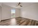 Wood-look floors, ceiling fan, crown molding, and a window overlooking the backyard at 2679 Haines Bayshore Rd, Clearwater, FL 33760