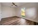 Cozy bedroom with hardwood floors, ceiling fan, and large backyard-viewing window at 2679 Haines Bayshore Rd, Clearwater, FL 33760