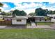 Beautifully landscaped front yard with an asphalt driveway, mature trees, and well-maintained lawn at 2679 Haines Bayshore Rd, Clearwater, FL 33760