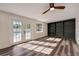Living room with hardwood floors, ceiling fan, built-in bookshelf and backyard access at 2679 Haines Bayshore Rd, Clearwater, FL 33760