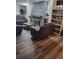 Comfortable living room featuring a stone fireplace, hardwood floors, and cozy seating area with brown leather furniture at 2679 Haines Bayshore Rd, Clearwater, FL 33760