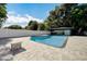 Inviting pool area with a pristine blue pool, spacious paver patio, cabana, and lush green landscaping for outdoor enjoyment at 2679 Haines Bayshore Rd, Clearwater, FL 33760