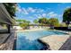 Backyard with an inviting pool, paver patio, lush landscaping, and plenty of space for outdoor activities at 2679 Haines Bayshore Rd, Clearwater, FL 33760