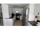 Bright kitchen featuring white cabinets, stainless steel appliances, and dark countertops at 2797 Cordova S Way, St Petersburg, FL 33713