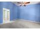 Bedroom with blue walls, ceiling fan, and doorways to closet and ensuite bathroom at 3066 Landmark Blvd # 1305, Palm Harbor, FL 34684