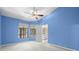 Bedroom with blue walls, large windows, and doorway to an outside space at 3066 Landmark Blvd # 1305, Palm Harbor, FL 34684