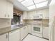 Kitchen features stainless sink, white appliances, and ample cabinet space at 3066 Landmark Blvd # 1305, Palm Harbor, FL 34684